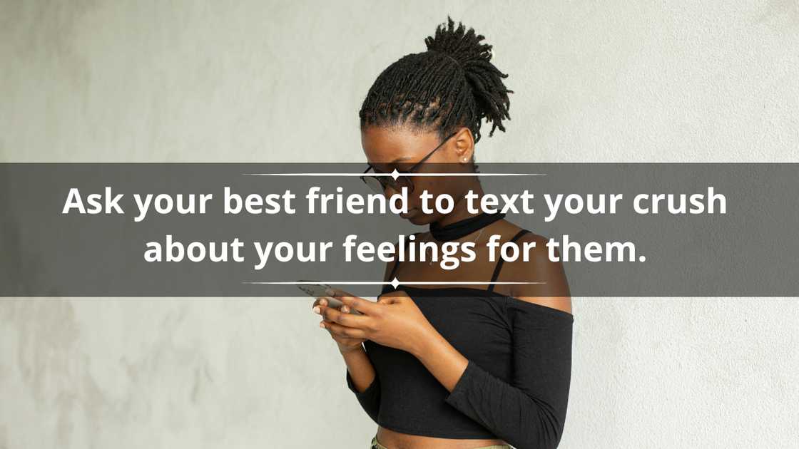 A young lady in dreadlocks and a black crop top is texting on a smartphone A young lady in dreadlocks and a black crop top is texting on a smartphone