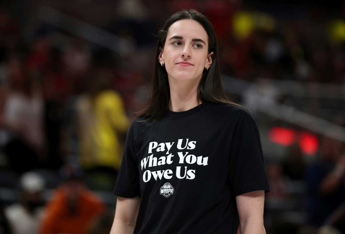 WNBA star Caitlin Clark of the Indiana Fever wears a T-shirt saying, "Pay us what you owe us," as a message over struggling talks over a new union agreement during last month's WNBA All-Star Game WNBA star Caitlin Clark of the Indiana Fever wears a T-shirt saying, "Pay us what you owe us," as a message over struggling talks over a new union agreement during last month's WNBA All-Star Game