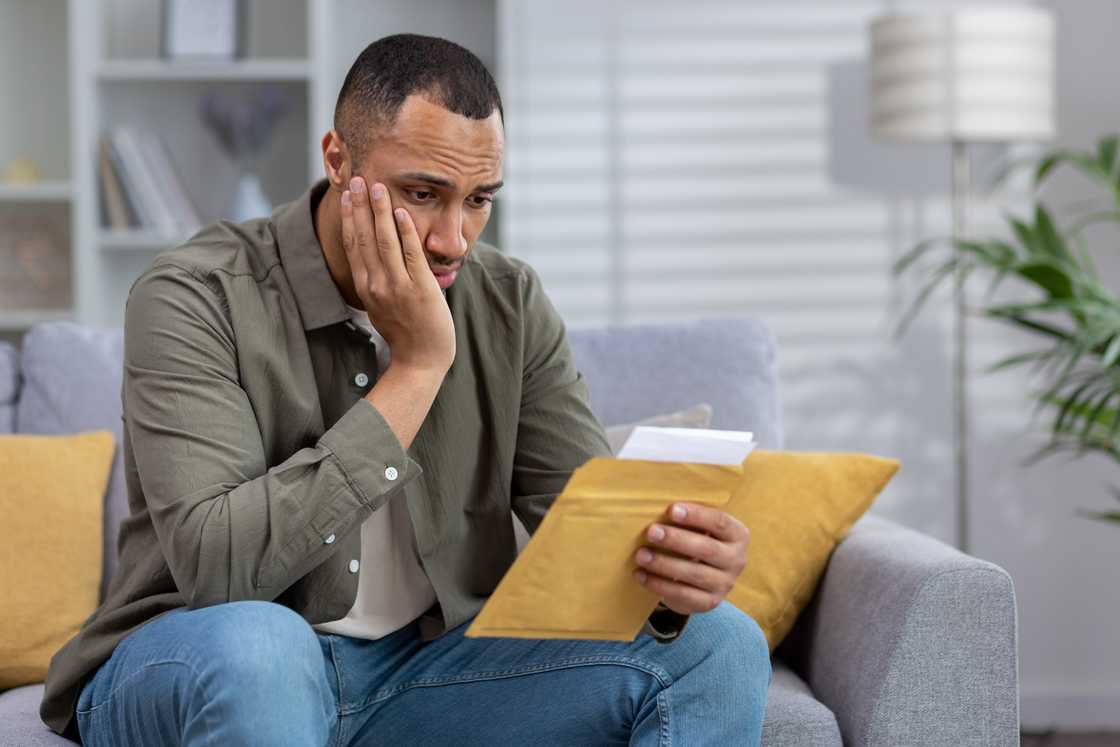 tense man holding staring at a manila envelope