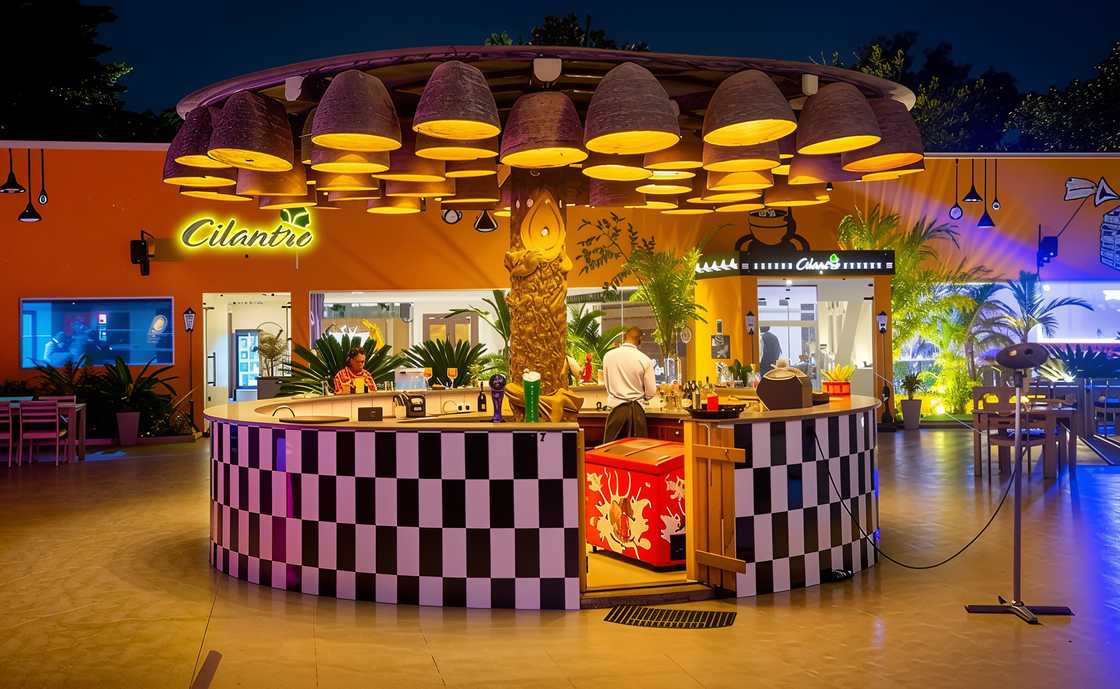 A bartender prepares drinks at Cilantro Restaurant and Lounge's tropical-themed bar area.