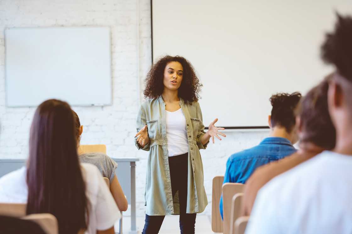 A woman addressing a seated group. A woman addressing a seated group.