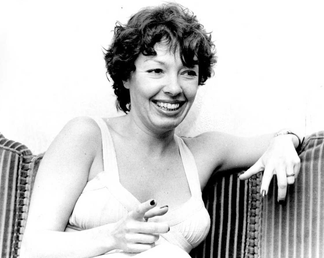 Elizabeth Weber seated on a couch as she smiles Elizabeth Weber seated on a couch as she smiles