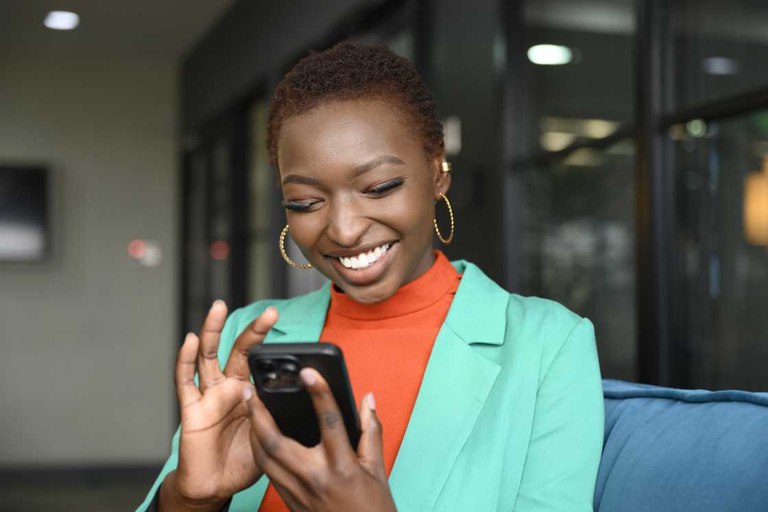 Cheerful young business professional using smart phone.