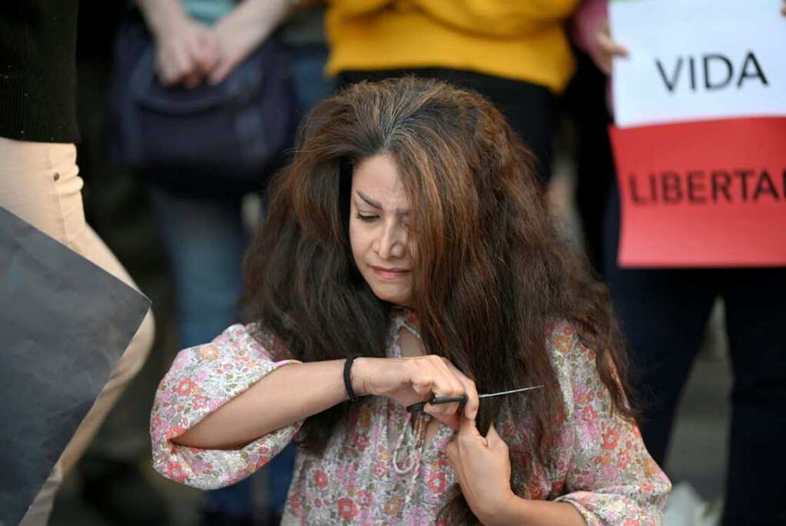A protester cuts her hair during a demonstration in support of Mahsa Amini on October 1, 2022 in Madrid A protester cuts her hair during a demonstration in support of Mahsa Amini on October 1, 2022 in Madrid