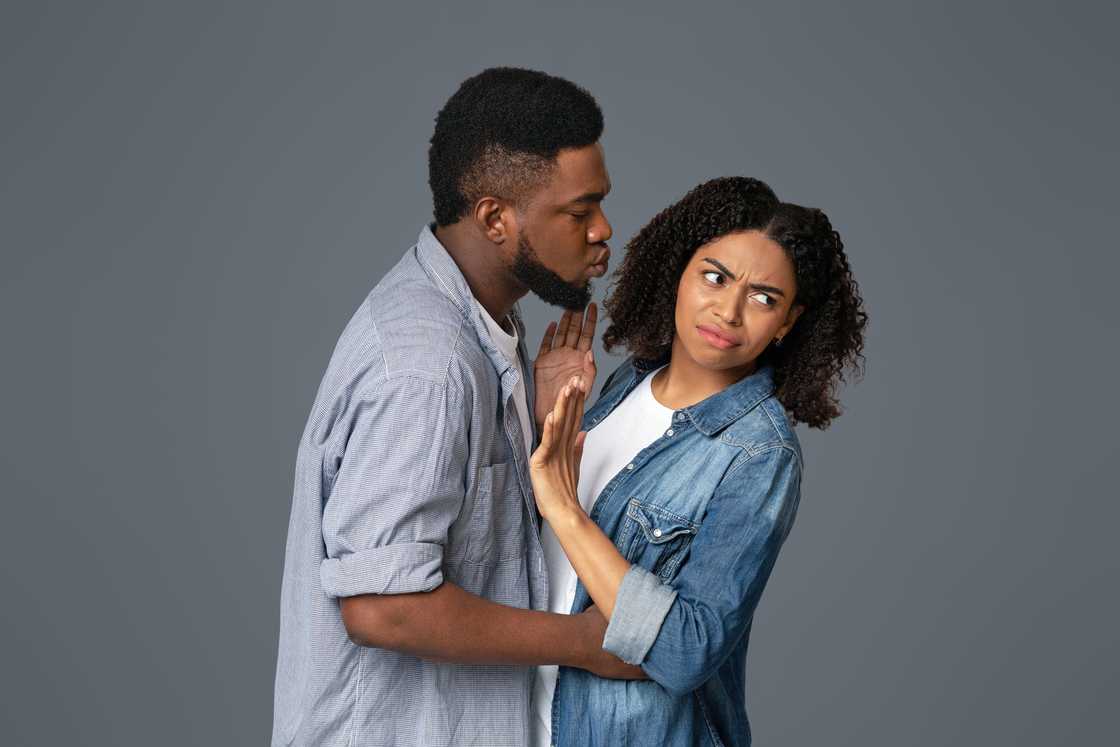 Angry woman rejecting a kiss from a man Angry woman rejecting a kiss from a man