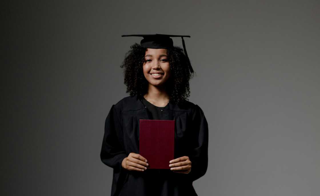 A lady in a graduation gown smiling