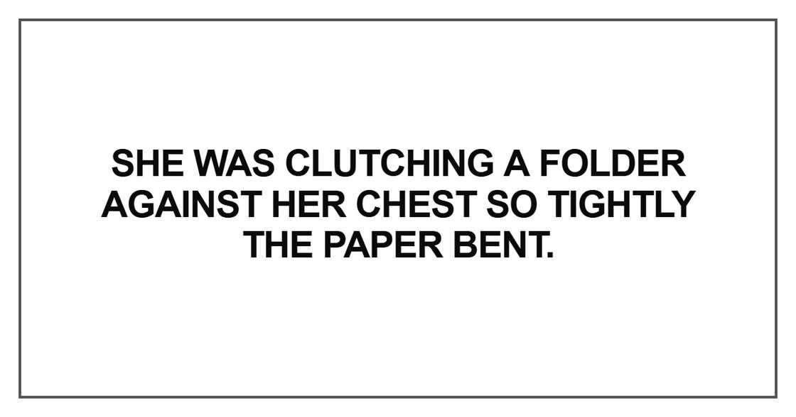 She was clutching a folder against her She was clutching a folder against her