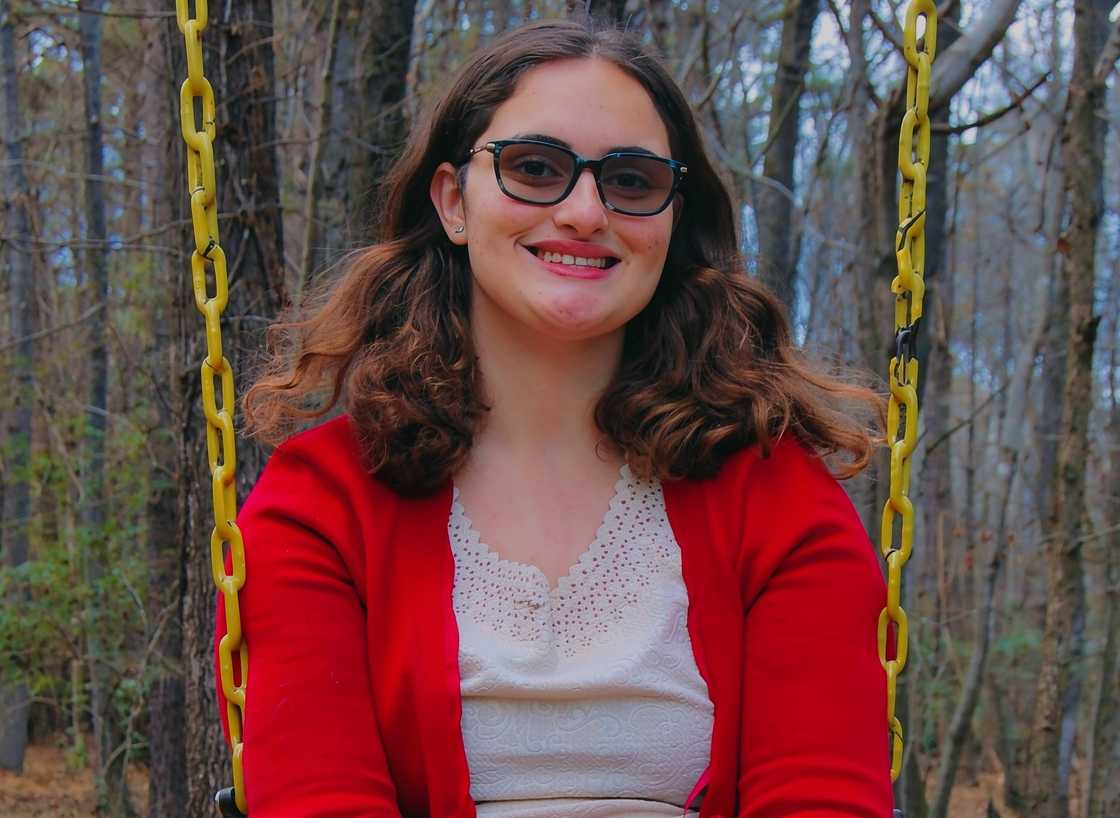 Georgie Harris sits on a swing outdoors