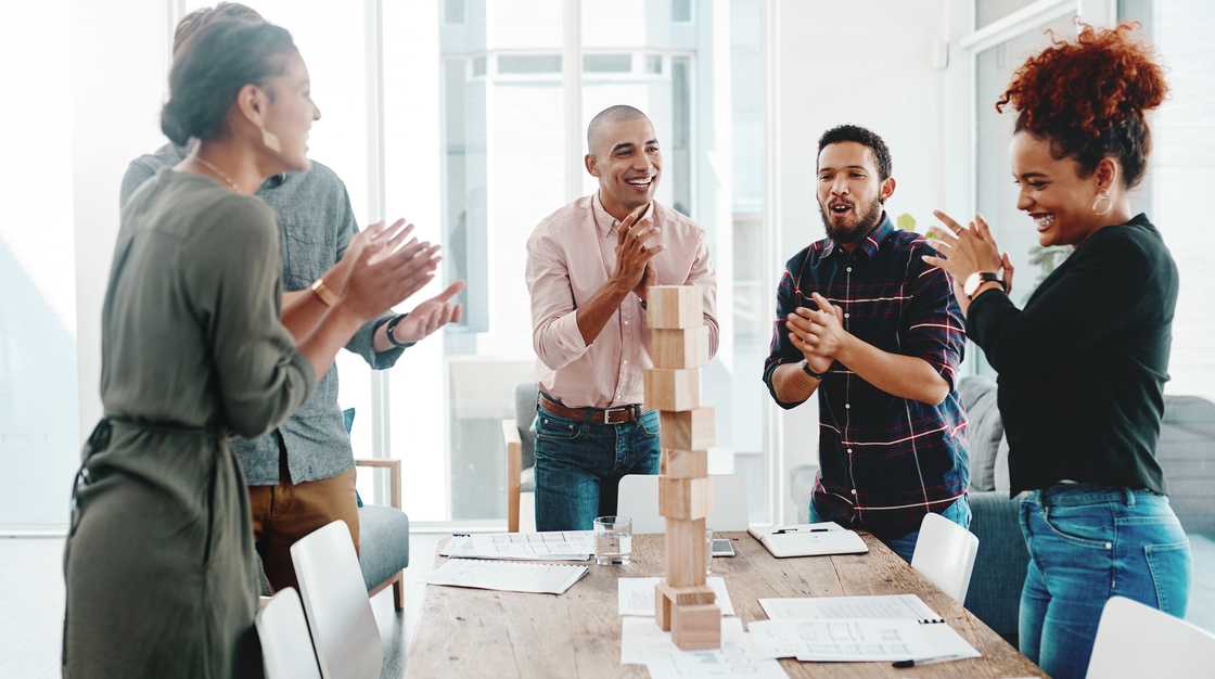A group of young businesspeople having a meeting with building blocks in a modern office. A group of young businesspeople having a meeting with building blocks in a modern office.