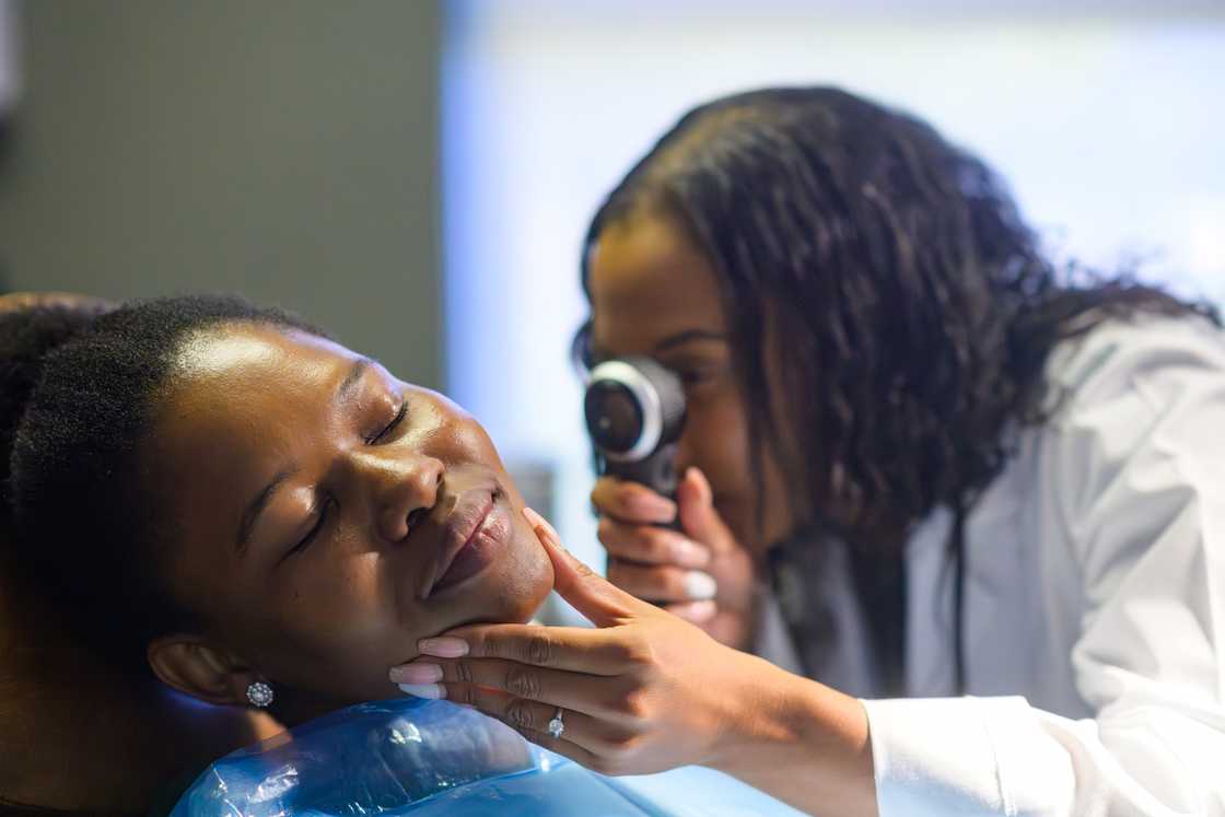 A skincare specialist examines a client