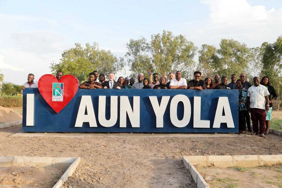 Students posing behind the AUN sign Students posing behind the AUN sign