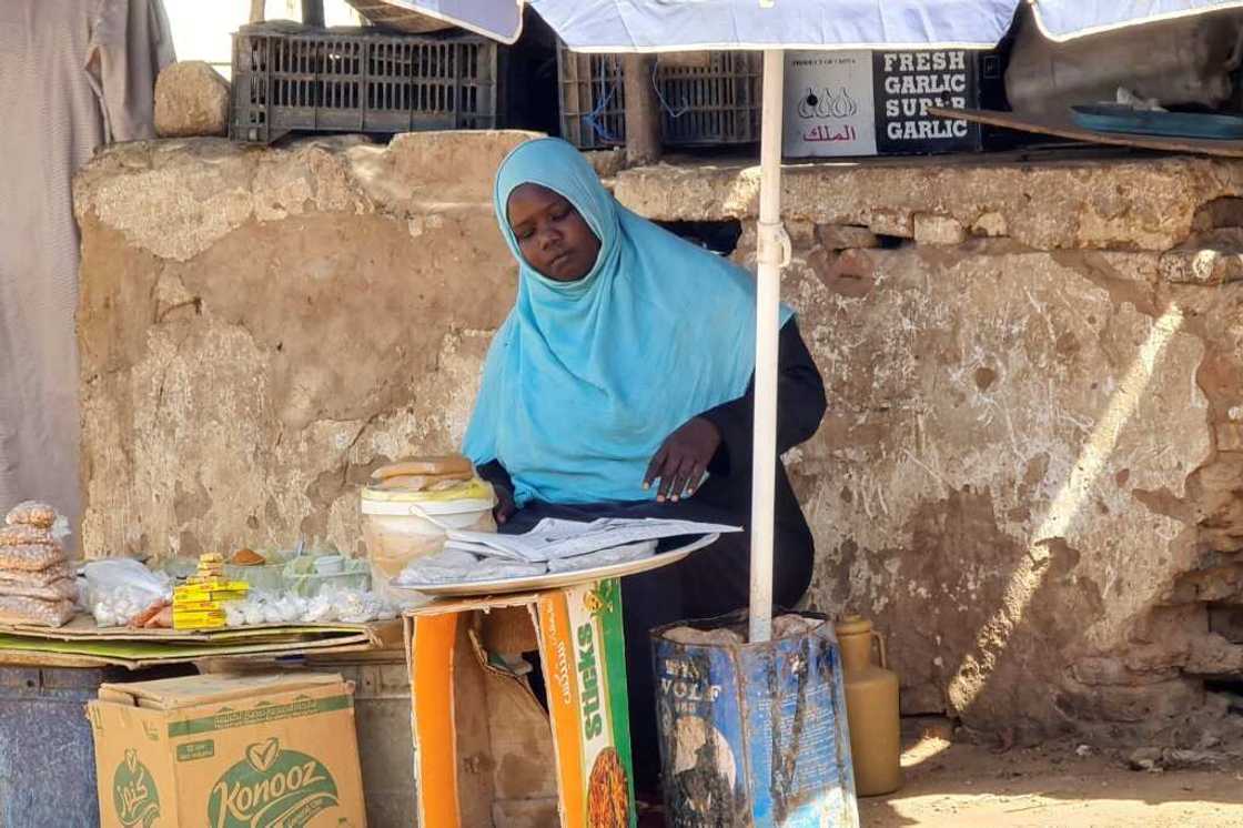 A woman sells foodstuffs at a stall in a Khartoum street as she tries to make a living amid the near-daily air strikes and artillery bombardments A woman sells foodstuffs at a stall in a Khartoum street as she tries to make a living amid the near-daily air strikes and artillery bombardments