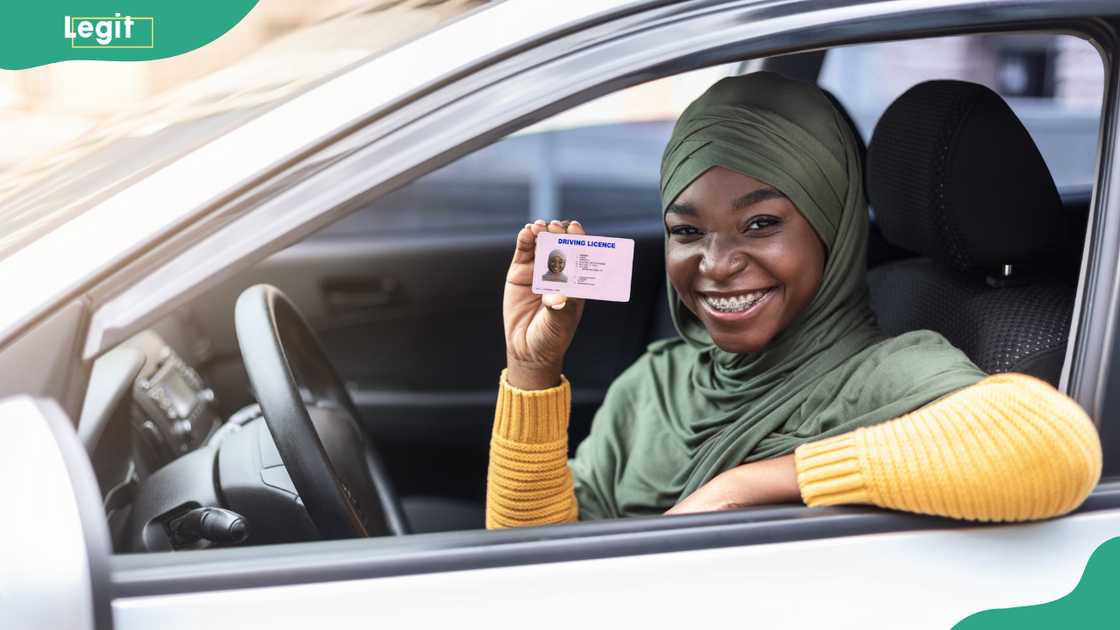A female driver holds a driver's licence. A female driver holds a driver's licence.