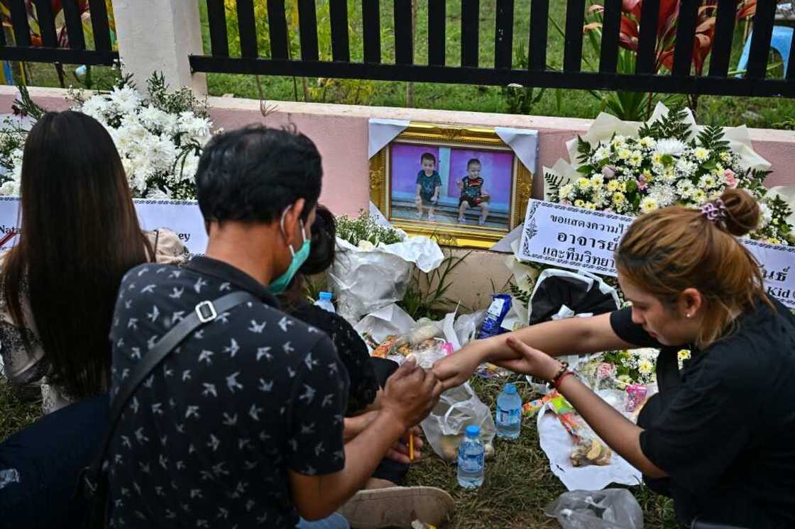 Around a low fence surrounding the single-storey, pink-roofed nursery where just a few days ago youngsters played happily, piles of flowers built up Around a low fence surrounding the single-storey, pink-roofed nursery where just a few days ago youngsters played happily, piles of flowers built up