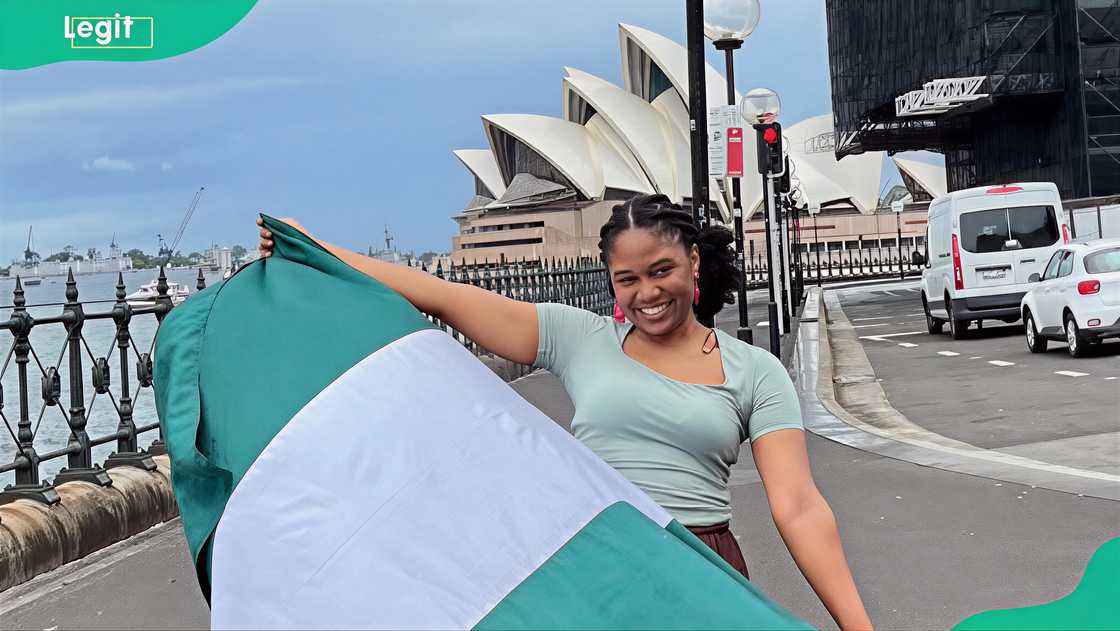 A Nigerian lady posing with the Nigerian flag with the Sydney Opera House behind A Nigerian lady posing with the Nigerian flag with the Sydney Opera House behind