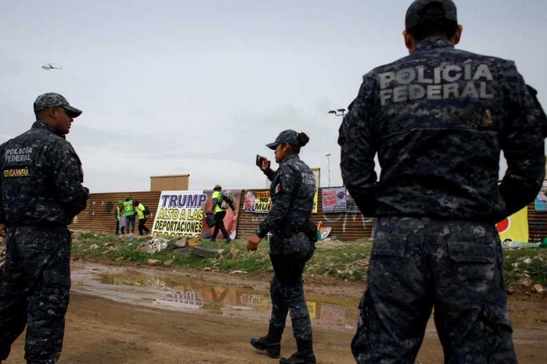 Mexican police watch a protest against US president Donald Trump's migration policies in Tijuana Mexican police watch a protest against US president Donald Trump's migration policies in Tijuana