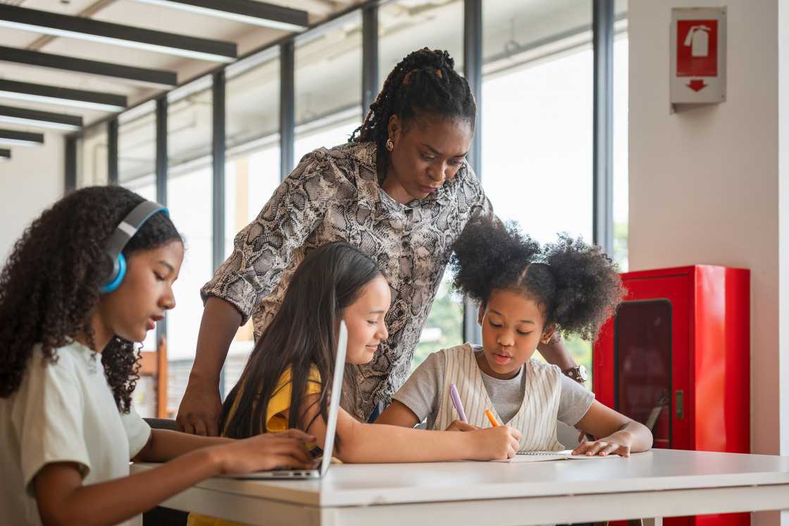 A teacher encourages pupils during quiet reflection time.