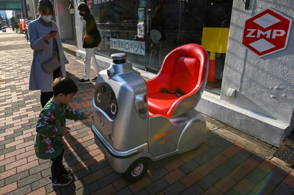 A child and his mother look at a mobility robot RakuRo, developed by Tokyo-based robotics firm ZMP, at the company's service station in Tokyo A child and his mother look at a mobility robot RakuRo, developed by Tokyo-based robotics firm ZMP, at the company's service station in Tokyo