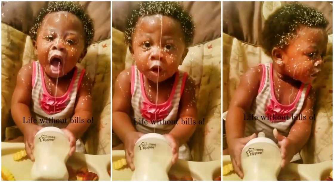 Baby boy helps himself with some milk.