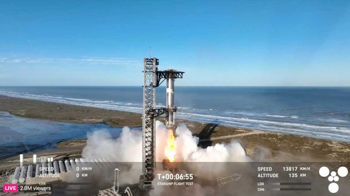 In this screen grab taken from the SpaceX broadcast the Starship's Super Heavy Booster is being grappled mid-air as it returns to the launch pad at Starbase near Boca Chica, Texas, on January 16, 2025