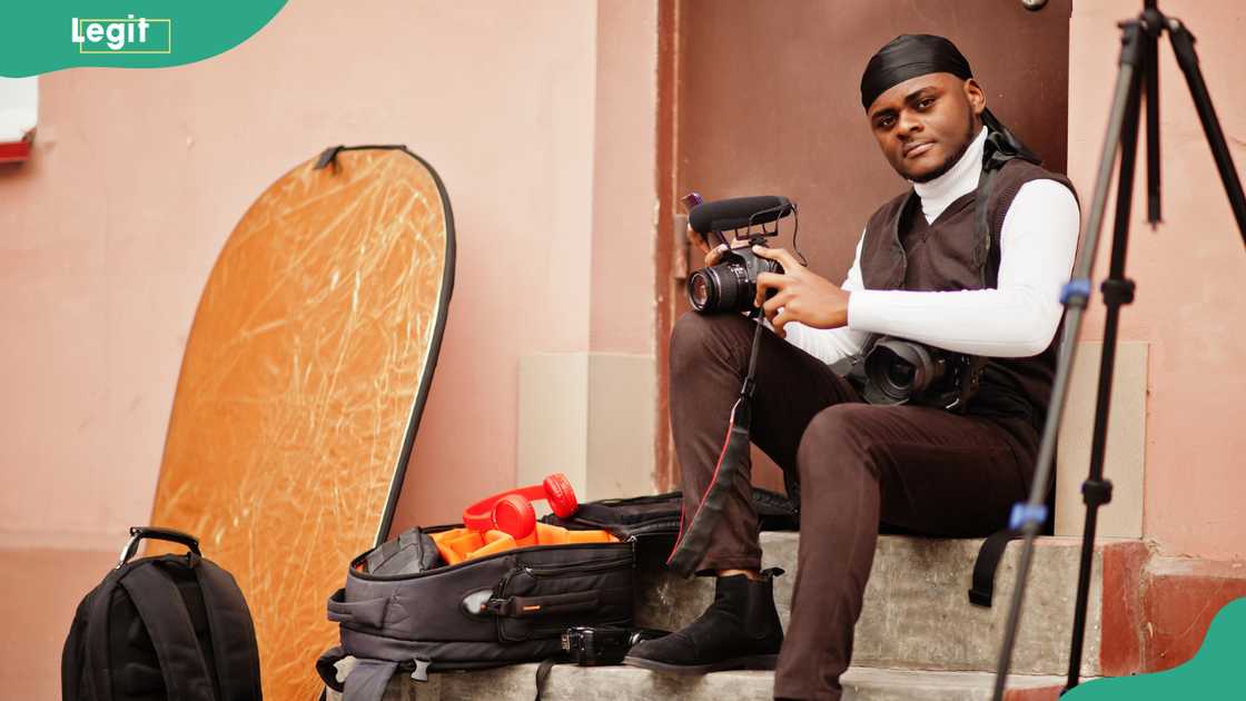 A man holding a professional camera with a mounted microphone A man holding a professional camera with a mounted microphone