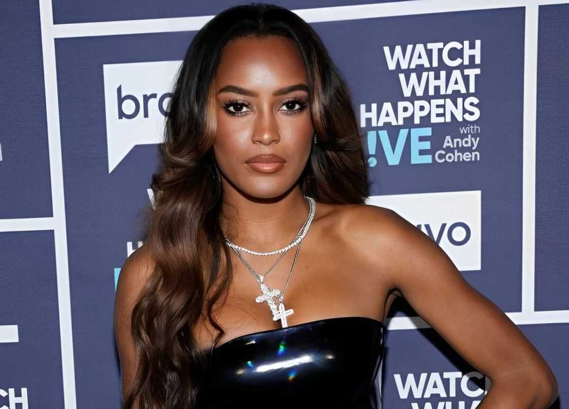 Ciara Miller poses for a photo in a black dress