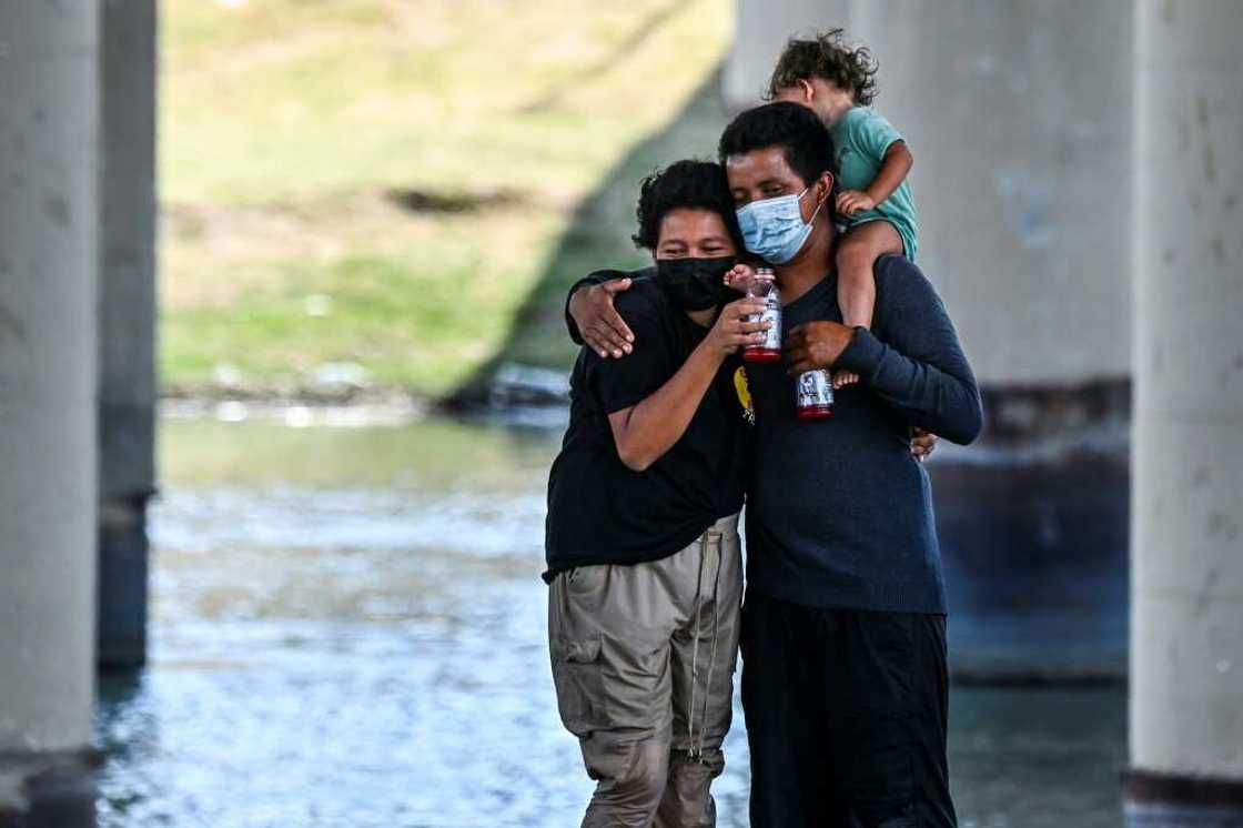 A migrant couple hug after successfully crossing the Rio Grande