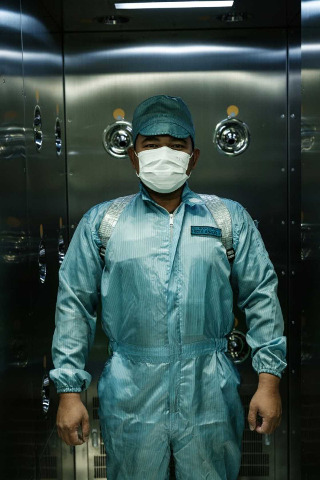 An employee wears a protective suit to avoid spreading dust at the PT HLI Green Power plant