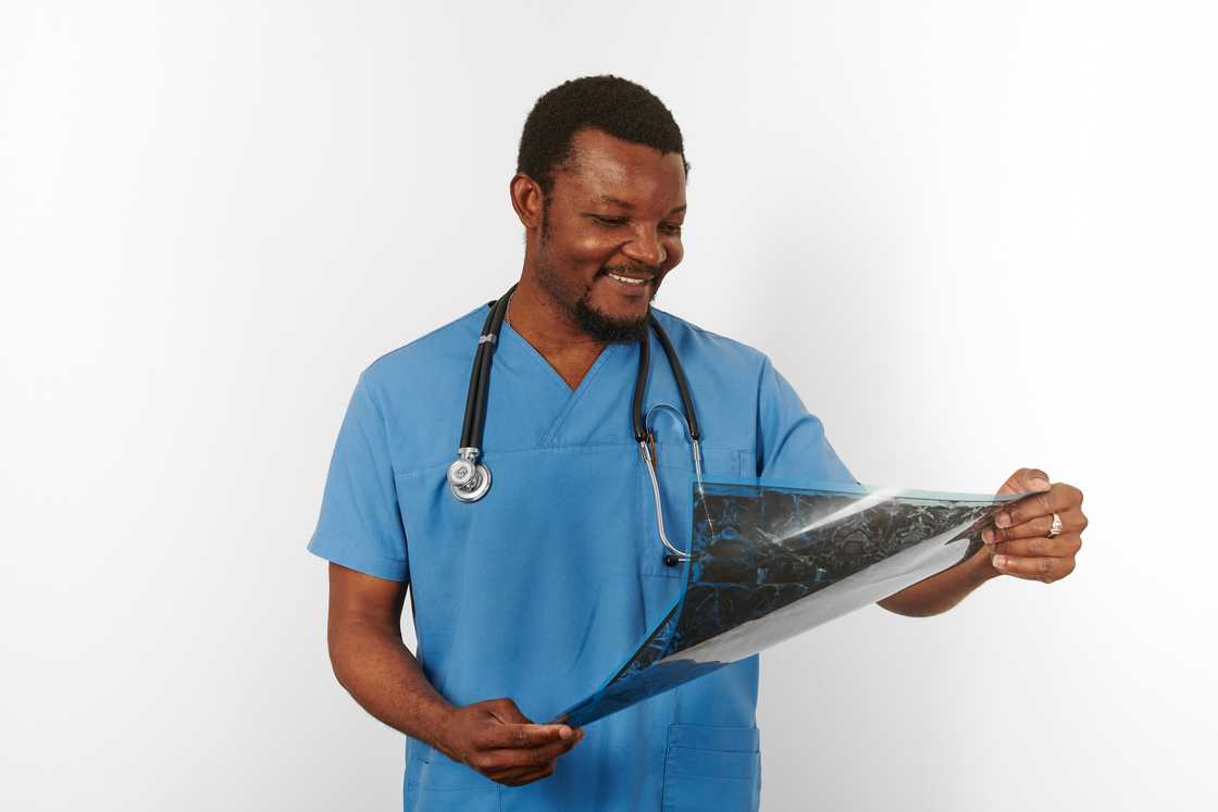 A male surgeon doctor with a stethoscope holding X ray image.
