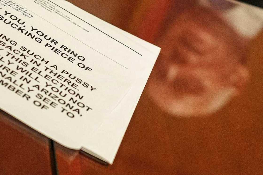 The reflection of Arizona's Russell Bowers is seen beyond a printed copy of a threatening email he received The reflection of Arizona's Russell Bowers is seen beyond a printed copy of a threatening email he received