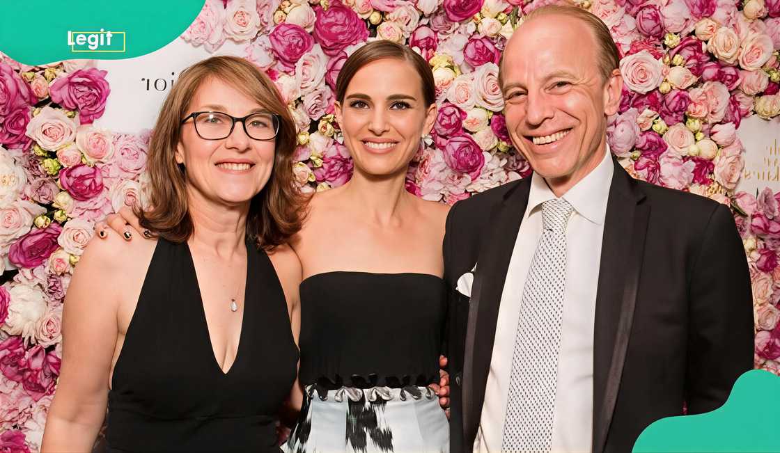 Shelley Stevens, Natalie Portman,and Avner Hershlag pose infront of a wall flower arrangement