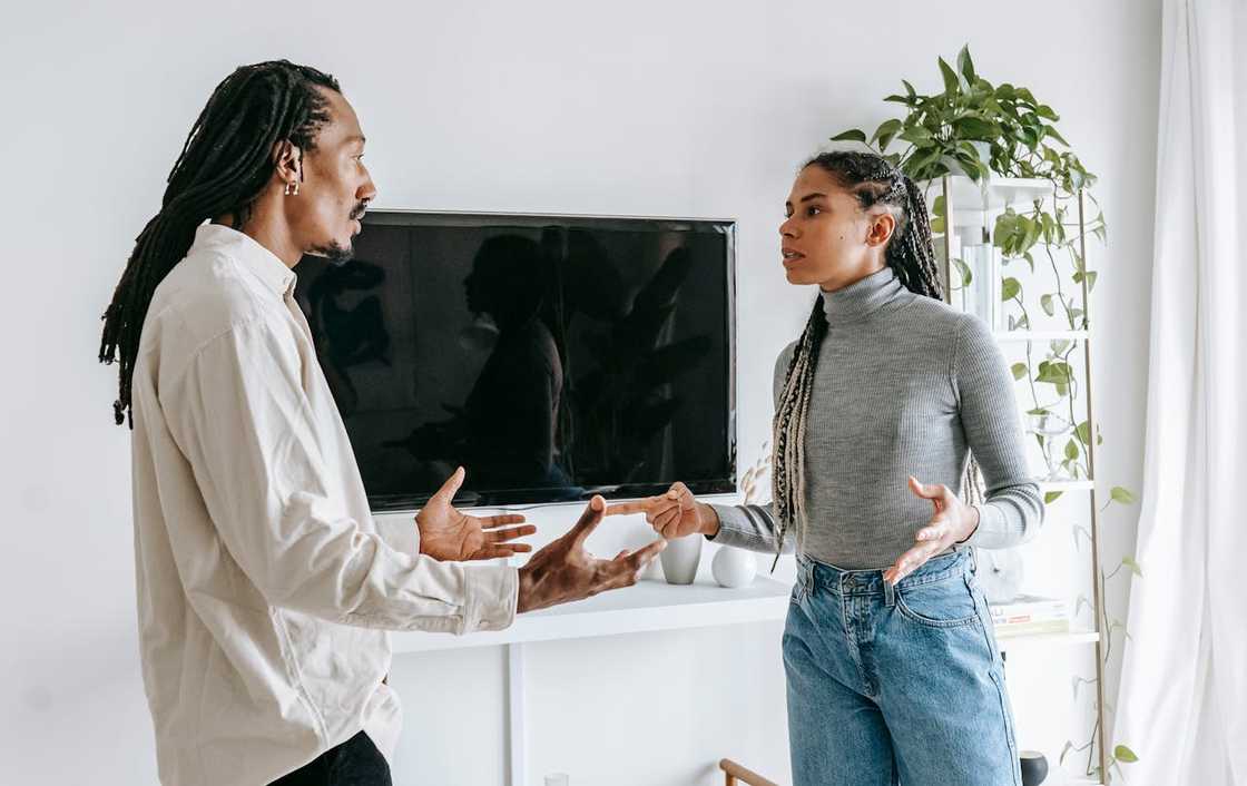 Couple arguing in a living room during a tense discussion.