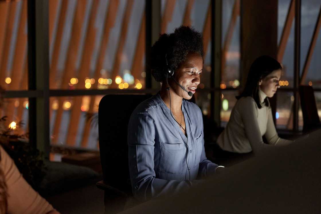 A call centre agent listens during a long late-night call.