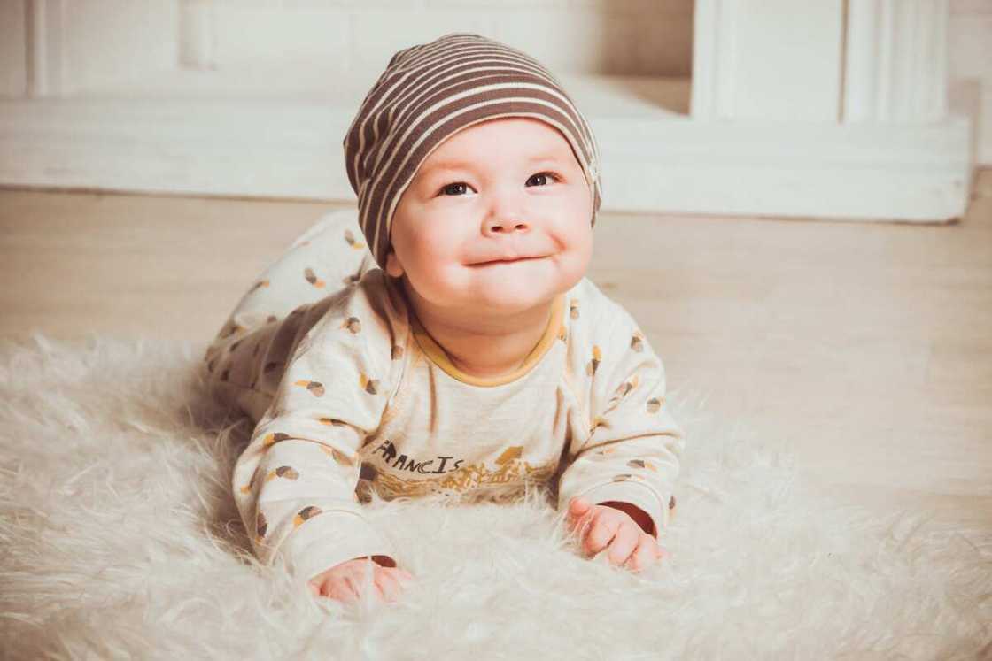 A baby laying on a fur rug