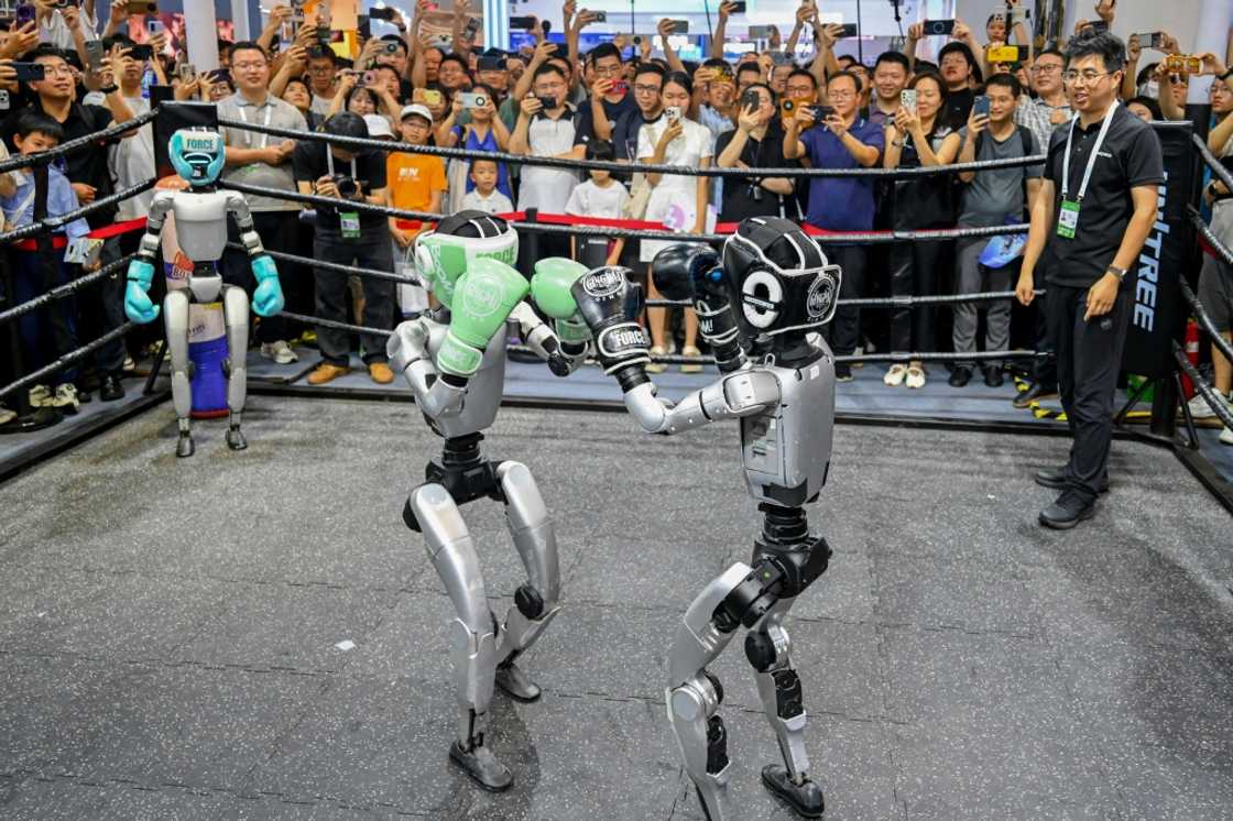 People watch humanoid robots boxing at an exhibition during the World AI Conference in Shanghai People watch humanoid robots boxing at an exhibition during the World AI Conference in Shanghai