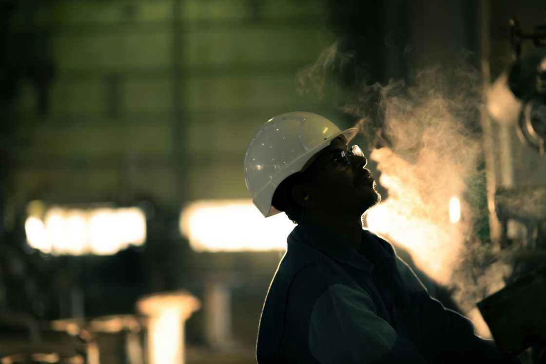 A production engineer in a dark steamy room A production engineer in a dark steamy room