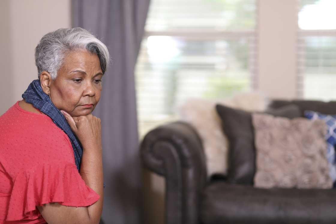 A sad and depressed senior woman at home.