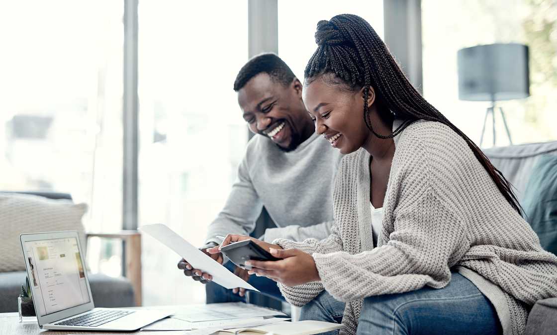 A young couple going through paperwork at home.