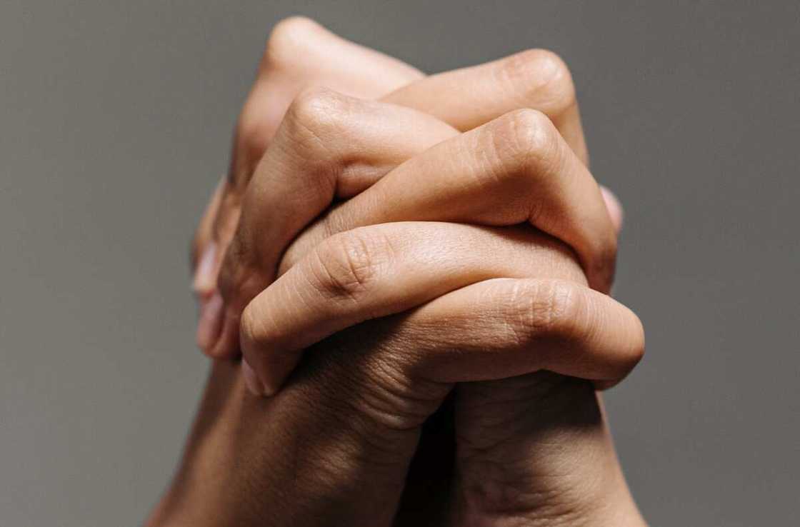A close up photo of clasped hands A close up photo of clasped hands
