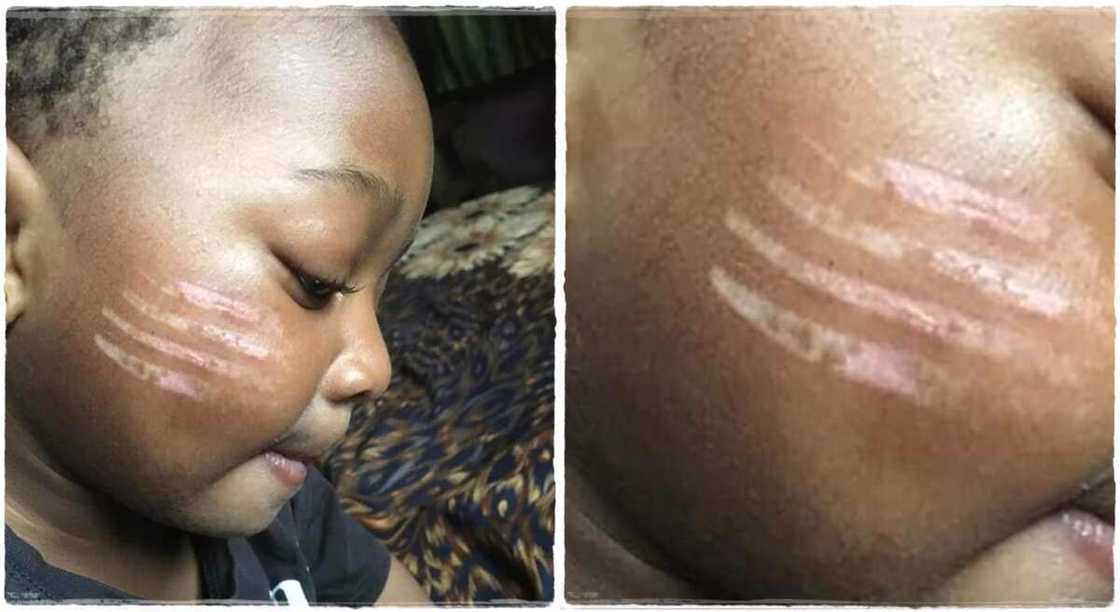 Child given tribal marks by a teacher. Child given tribal marks by a teacher.