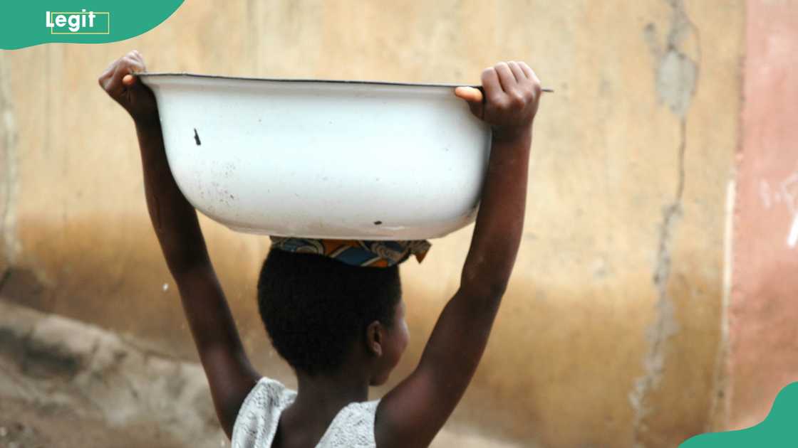 A idiosyncratic   carrying a bucket of h2o  connected  their head