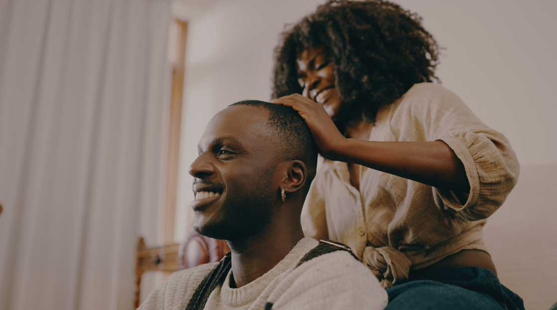 A lady brushes her man's hair