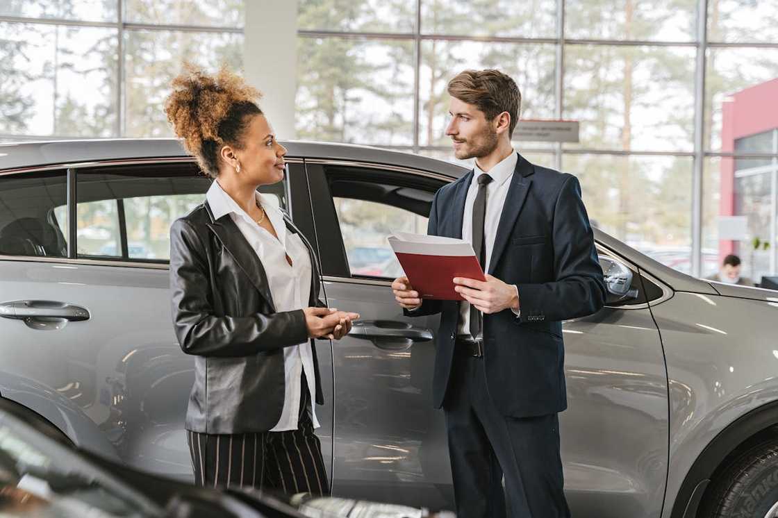 Woman stepping back from a vehicle, exhaling in relief after a successful inspection.