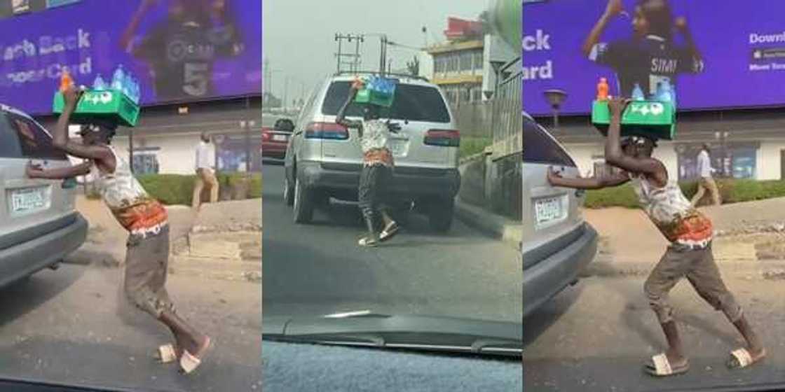 A young Nigerian hawking bottled water was seen helping to pushed a car in Lagos with is goods on his head. A young Nigerian hawking bottled water was seen helping to pushed a car in Lagos with is goods on his head.