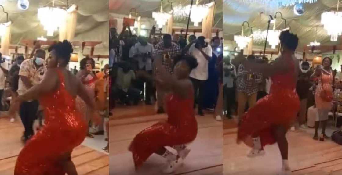 Female wedding guest in long one-armed dress dances with intense energy, people stand up for her in video Female wedding guest in long one-armed dress dances with intense energy, people stand up for her in video