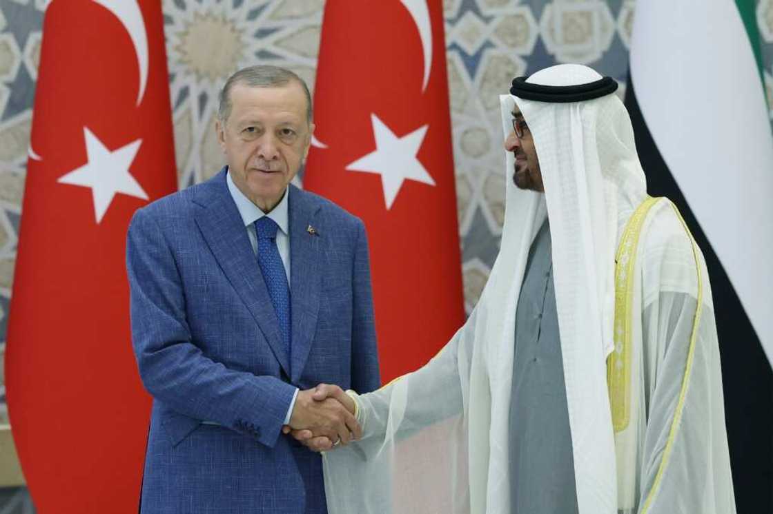 UAE President Mohamed bin Zayed Al Nahyan (R) greeting Turkey's President Recep Tayyip Erdogan