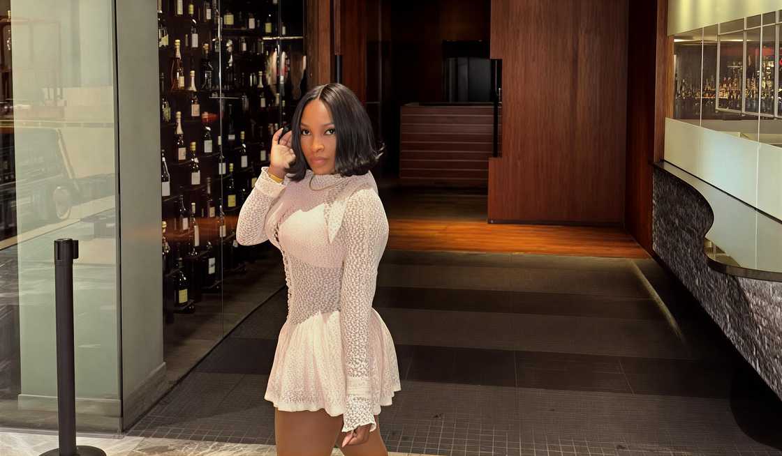 Lastonia Leviston poses wearing a light-colored cocktail mini dress at the entrance of Komodo restaurant. Lastonia Leviston poses wearing a light-colored cocktail mini dress at the entrance of Komodo restaurant.