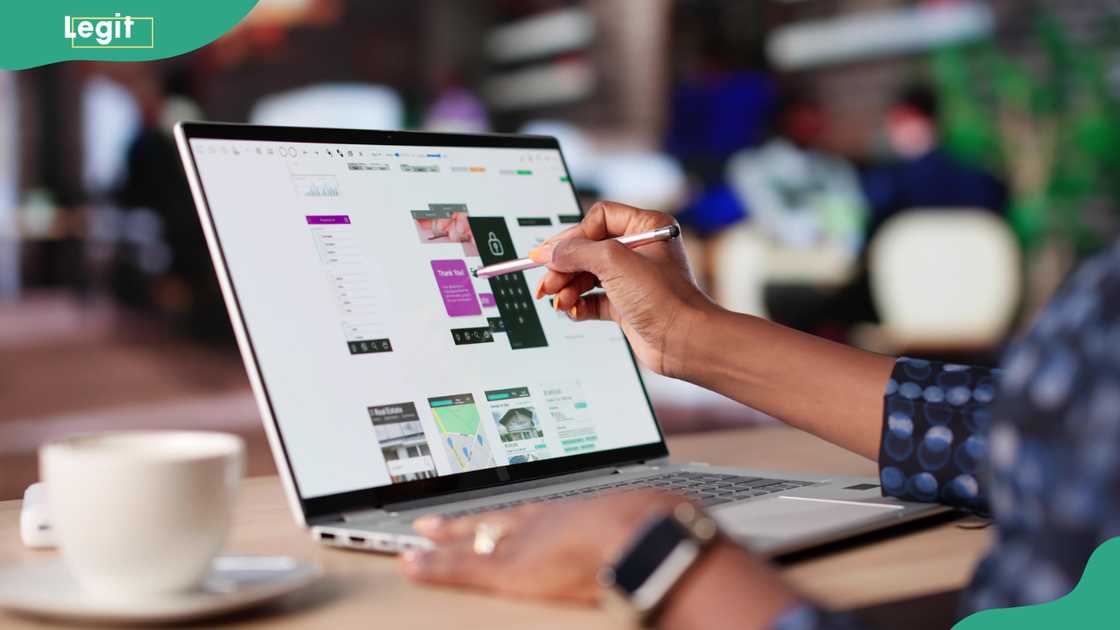 An African-American woman designing user interfaces at a cafe gallery.