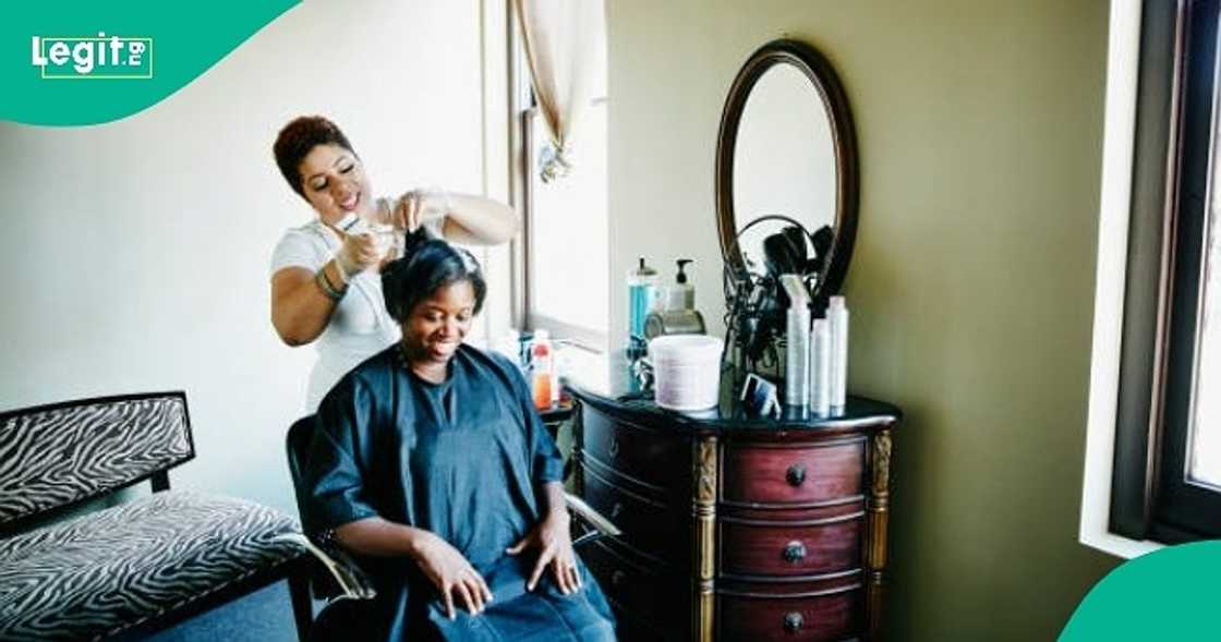 Hairdresser displays few strands of hair she mistakenly left out while braiding customer's hair.