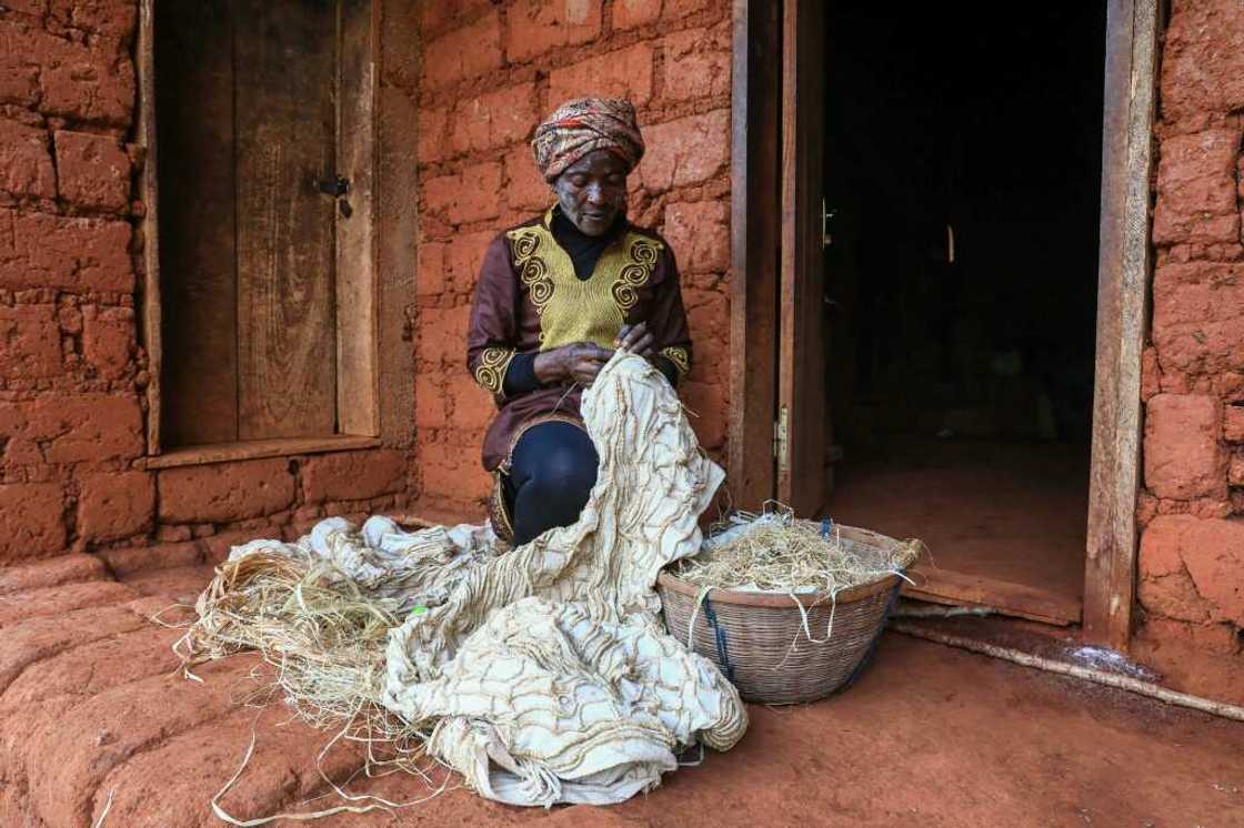 Hard work: Solange Yougo embroiders an as yet undyed piece of ndop cloth at her home in Baham Hard work: Solange Yougo embroiders an as yet undyed piece of ndop cloth at her home in Baham